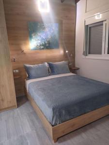 a bedroom with a large bed with blue sheets at Sweet cottage in Chanioporta in Heraklio Town