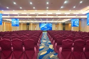 a conference room with red chairs and a stage at AP Premier Batam in Nagoya +38 photos