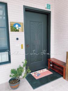 a black door on a brick building with a bench at Pi-thon In House in Yujing