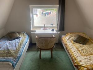 a bedroom with two beds and a desk and a window at Monteur Gäste Zimmer Stadt Hafen in Husum