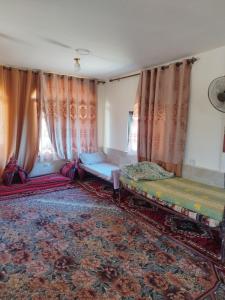 private room with cultural experience and great landscapes في Şirfah: غرفة بسريرين وستائر وسجادة