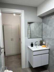 a bathroom with a white sink and a shower at Simply Elegant in Tel Aviv