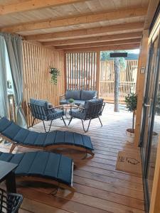 un patio con sillas y un sofá en una terraza de madera en InnMare Mobile Homes, en Biograd na Moru