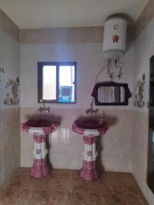 two pink sinks in a bathroom with a window at private room with cultural experience and great landscapes in Şirfah