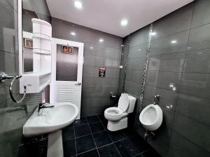 baño con lavabo, aseo y urinario en Cody Backpackers CNX en Chiang Mai