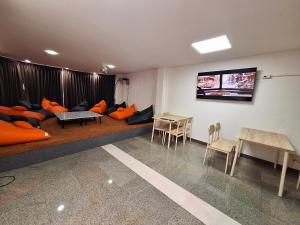 - un salon avec un canapé et une télévision dans l'établissement Cody Backpackers CNX, à Chiang Mai