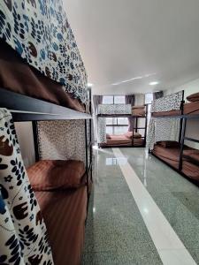 une chambre avec des lits superposés et une chambre avec un couloir dans l'établissement Cody Backpackers CNX, à Chiang Mai
