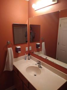 a bathroom with a sink and a large mirror at Lux stay book 7 nights minimum and save in Jacksonville