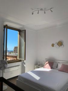 Habitación blanca con cama y ventana en La finestrella sul porto, en Génova
