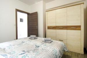 a bedroom with a bed and a large cabinet at Apartman Paštura in Vodnjan