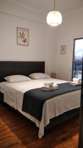 1 dormitorio con 1 cama grande con sábanas blancas y ventana en Beach Retreat in town en Kórinthos