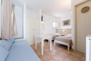 - une petite chambre avec 2 lits et une table dans l'établissement Rocco's studios, à Antiparos