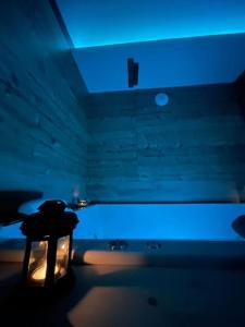ein dunkles Zimmer mit einem Tisch und einem blauen Licht in der Unterkunft Zen Room in LʼIsle-sur-le-Doubs
