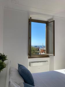 1 dormitorio con ventana y 1 cama con almohada en La finestrella sul porto, en Génova