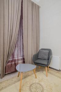 une chaise et une table dans une chambre avec fenêtre dans l'établissement Studio Rentals, à Chişinău