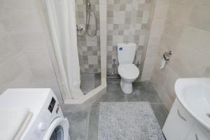La salle de bains est pourvue de toilettes, d'une douche et d'un lave-linge. dans l'établissement Studio Rentals, à Chişinău