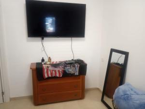 uma televisão de ecrã plano numa parede com uma cómoda em דירת שי em Rishon LeZion