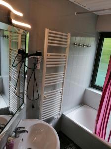 uma casa de banho com um lavatório e uma banheira em Haus Mohr - Ferienwohnung im Taunus em Weilmünster