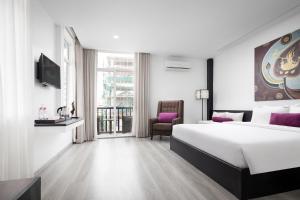 een hotelkamer met een groot bed en een balkon bij Apsor Palace Hotel in Phnom Penh