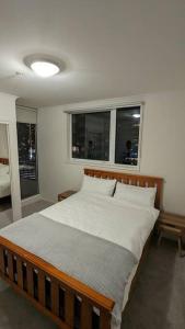 een slaapkamer met een bed met witte lakens en ramen bij 3 bedroom condo opposite casino. in Melbourne