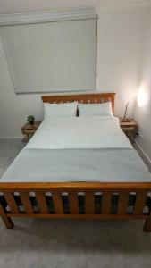 a wooden bed in a room with two tables at 3 bedroom condo opposite casino. in Melbourne