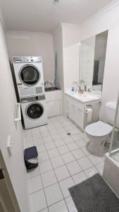 a bathroom with a washing machine and a sink at 3 bedroom condo opposite casino. in Melbourne