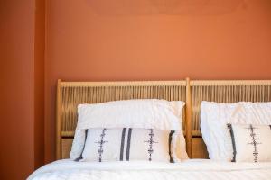 1 cama con 2 almohadas y pared de color naranja en Romantische Studio in Harmoniewijk, en Amberes