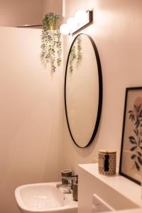 baño con lavabo y espejo en la pared en Romantische Studio in Harmoniewijk, en Amberes
