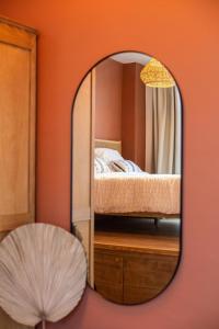 a mirror in a room with a bed and a fan at Romantische Studio in Harmoniewijk in Antwerp