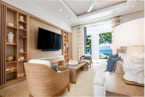 a living room with a couch and a tv at One Beachlands - Luxury Beachfront Mansion in Saint James