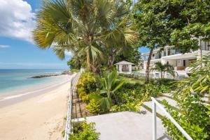 a view of the beach from the balcony of a resort at One Beachlands - Luxury Beachfront Mansion in Saint James