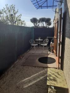 d'une terrasse avec une table, des chaises et une clôture. dans l'établissement Studio- Terrasse -Place de parking privé, à Marseille
