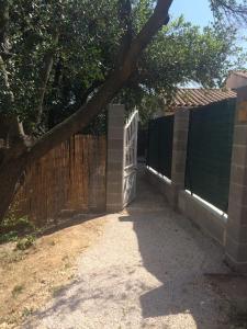 une clôture avec un portail et un arbre dans l'établissement Studio- Terrasse -Place de parking privé, à Marseille