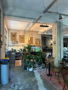 a large room with tables and chairs and plants at KOZA HOSTEL Coffee & Chill in Çekirge