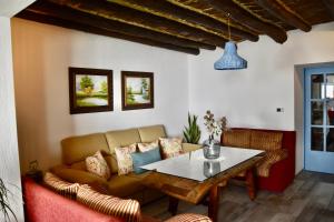 ein Wohnzimmer mit einem Sofa und einem Tisch in der Unterkunft Casa rural El Nido de Despeñaperros in Santa Elena