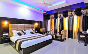 een slaapkamer met een groot bed en een tafel en stoelen bij Hotel Crystal Ganga Heights 5 Min from Har Ki Pauri in Haridwār +61 foto's