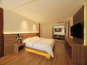 1 dormitorio con 1 cama y TV de pantalla plana en XILU INN muxin, en Lijiang