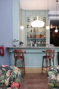 un bar en una habitación con 2 sillas y una mesa en Margot Old Tbilisi en Tiflis