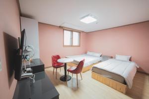 - une chambre avec un lit, une table et des chaises dans l'établissement Hotel Castle, à Suncheon