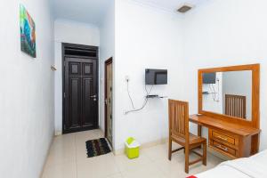 a bedroom with a mirror and a dresser and a door at RedDoorz near Wisata Museum Angkut 3 in Batu