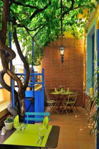 patio ze stołem i drzewem w obiekcie HOTEL RESTAURANT CORTIE w mieście Thuir