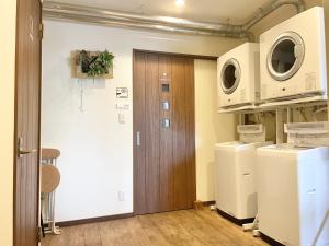 porta di accesso a una lavanderia con lavatrice e asciugatrice di YUKARA LEAF LODGE a Nanae