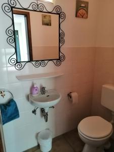 a bathroom with a sink and a toilet and a mirror at Haus Mohr - Ferienwohnung im Taunus in Weilmünster