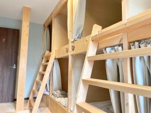 uma escada num quarto com prateleiras de madeira em YUKARA LEAF LODGE em Nanae