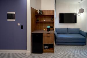 a living room with a blue couch and a tv at XANTHI POLIS CITY CENTER with private parking in Xanthi