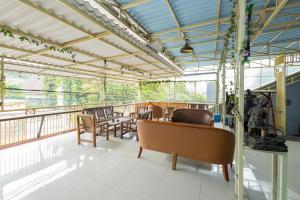 a room with tables and chairs on a balcony at RedDoorz near Wisata Museum Angkut 3 in Batu