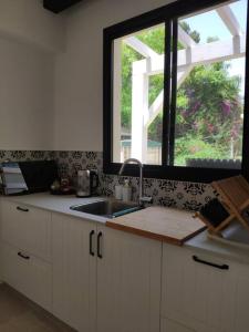a kitchen with a sink and a window at בקתה במרכז המושבה in Pardes H̱anna