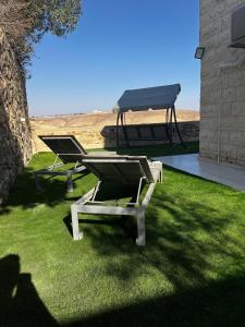 een picknicktafel met een grill op het gras bij לב במדבר - הצימר של רחלי in Arad