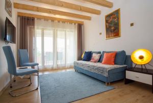 un soggiorno con divano blu e sedia di Apartment Villa Slavija a Briševo