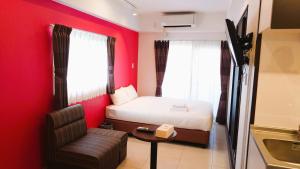宜野湾市にあるBiBi Hotel FUTENMAのベッドと椅子付きの小さな部屋です。